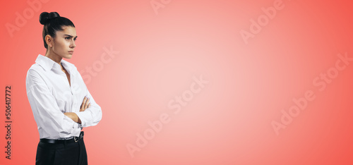Resentment and unpleasant emotions concept with stressed young woman in white shirt crossing her arms isolated on red background with blank place for you logo or text, template photo