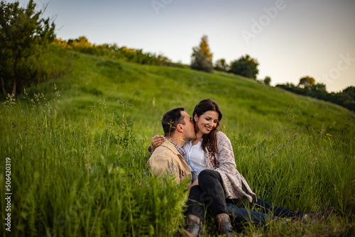 village couple in love gossiping gently peacefully, sitting facing each other man kissing girl in old-fashioned retro clothes
