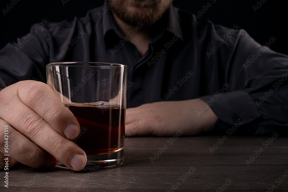 Lonely man drinks alcohol in the dark.