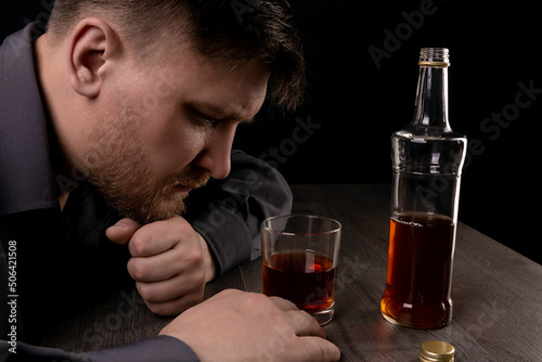 Lonely man drinks alcohol in the dark.