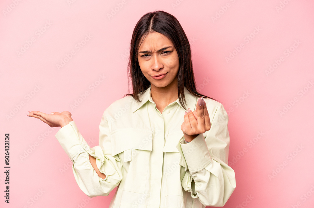 Young hispanic woman isolated on pink background showing that she has no money. Young hispanic woman isolated on pink background showing that she has no money.