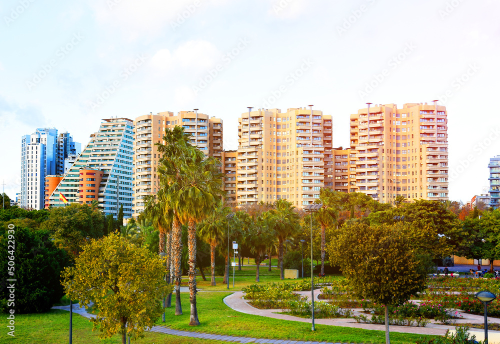 City park with gardens and green trees. Valencia Central Park on Turia River. Green trees in park. Fresh and clean air in a park with deciduous and coniferous trees. Facade of a building in city. City park with gardens and green trees. Valencia Central Park on Turia River. Green trees in park. Fresh and clean air in a park with deciduous and coniferous trees. Facade of a building in city.