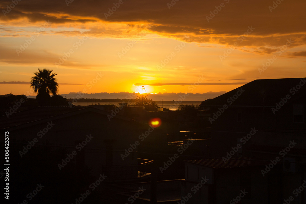 evocative image of sunset over the sea with headland silhouette in the background
evocative image of sunset over the sea with headland silhouette in the background