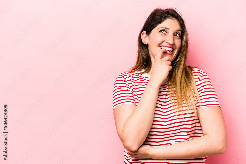 Young caucasian woman isolated on pink background relaxed thinking about something looking at a copy space. Young caucasian woman isolated on pink background relaxed thinking about something looking at a copy space.