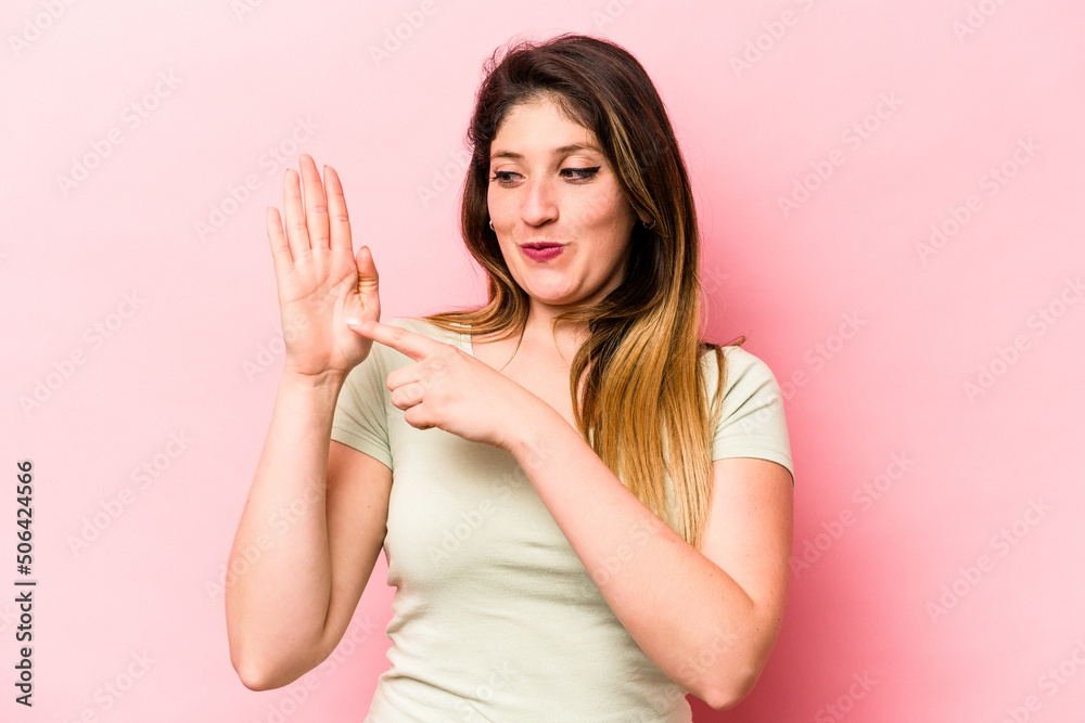 Young caucasian woman isolated on pink background smiling cheerful showing number five with fingers.
