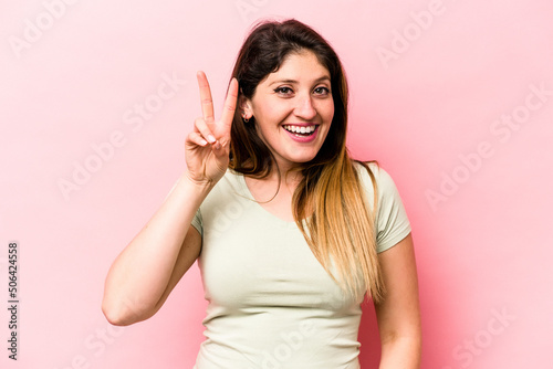 Young caucasian woman isolated on pink background showing number two with fingers. © Asier