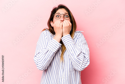 Young caucasian woman isolated on pink background biting fingernails, nervous and very anxious. © Asier