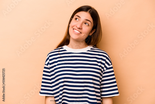 Young hispanic woman isolated on beige background relaxed and happy laughing, neck stretched showing teeth. © Asier