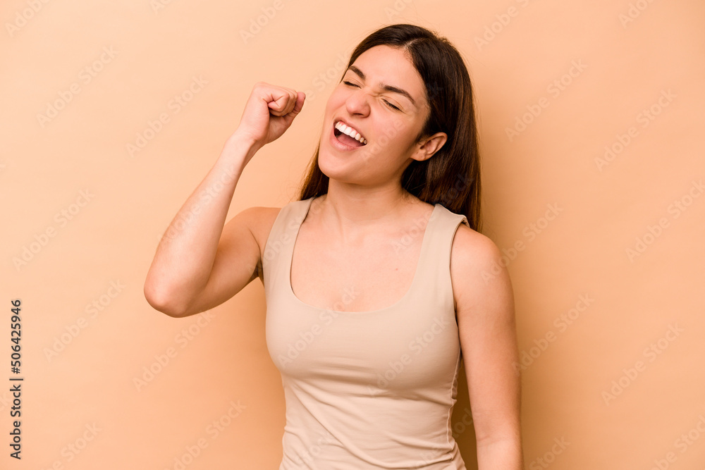 Fototapeta premium Young hispanic woman isolated on beige background celebrating a victory, passion and enthusiasm, happy expression.