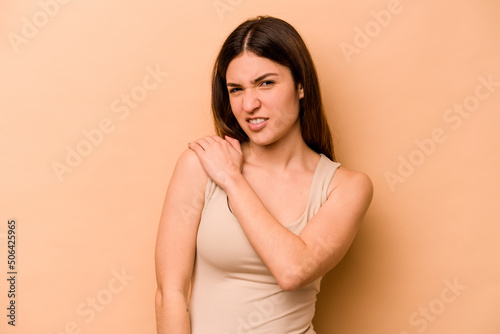 Young hispanic woman isolated on beige background having a shoulder pain.