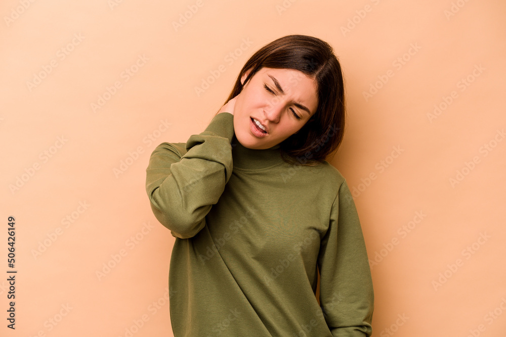 Young hispanic woman isolated on beige background suffering neck pain due to sedentary lifestyle. Young hispanic woman isolated on beige background suffering neck pain due to sedentary lifestyle.