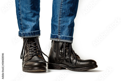 Man in black leather boots and jeans isolated on white background