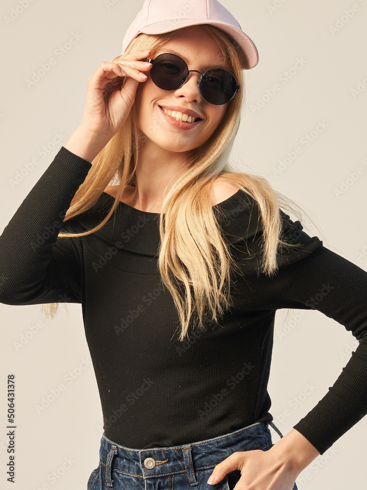 a young fashionable girl in dark glasses a cap a dark top on a white background a young fashionable girl in dark glasses a cap a dark top on a white background