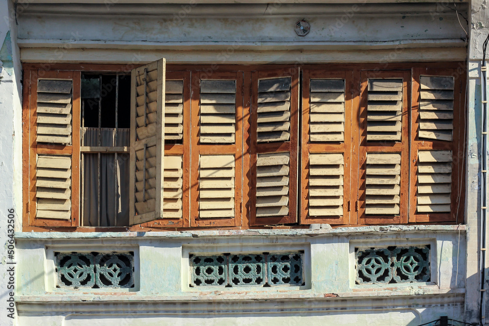 Detail of brown rectangular wooden windows of an old vintage shop house in the heritage town of Penang.