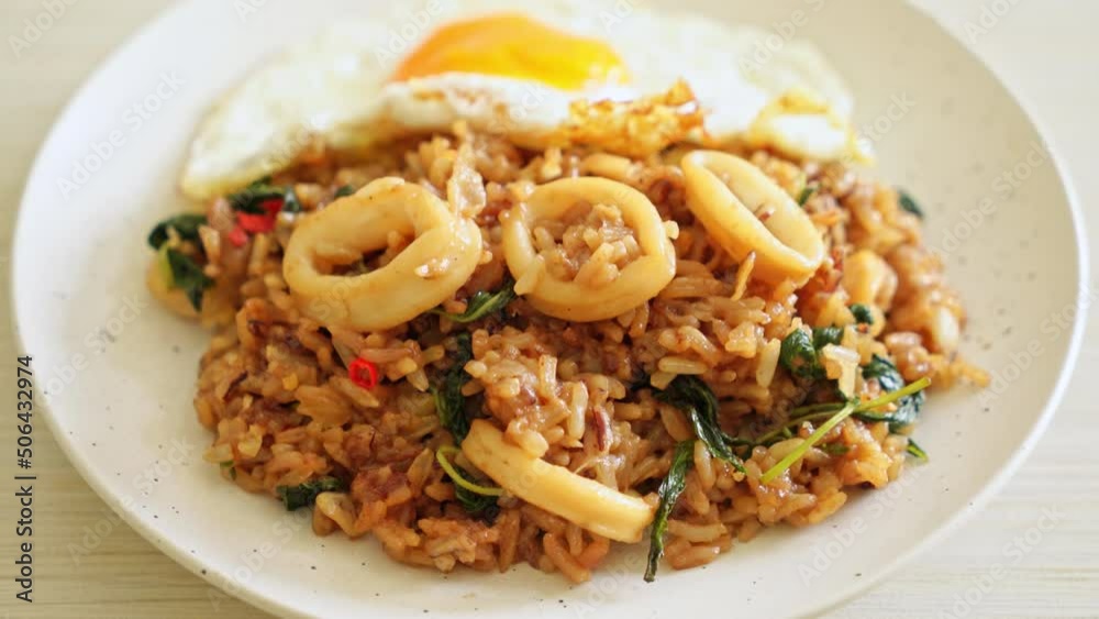 fried rice with squid and basil topped fried egg in Thai style - Asian food style fried rice with squid and basil topped fried egg in Thai style - Asian food style