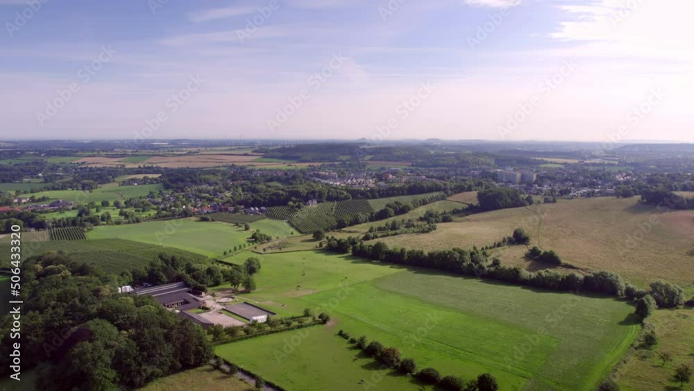 Aerial Drone View: Dutch valley landscape with roads, hills and farmlands, meadows and village landscape, with rural roads in South Limburg the Netherlands. Blue and purple sky in the background Aerial Drone View: Dutch valley landscape with roads, hills and farmlands, meadows and village landscape, with rural roads in South Limburg the Netherlands. Blue and purple sky in the background