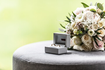 Open box with wedding rings placed next to a bouquette during a wedding