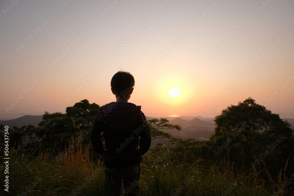 海に沈む夕日を眺める男の子 海に沈む夕日を眺める男の子