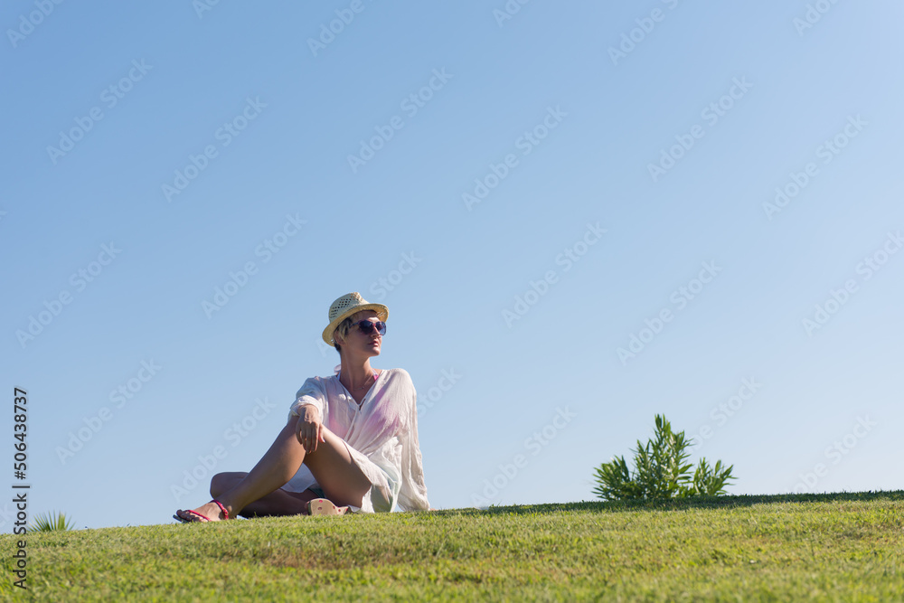 Woman lying and reading her favorite book on a meadow covered with fresh green grass on a sunny summer or spring day. Woman lying and reading her favorite book on a meadow covered with fresh green grass on a sunny summer or spring day.