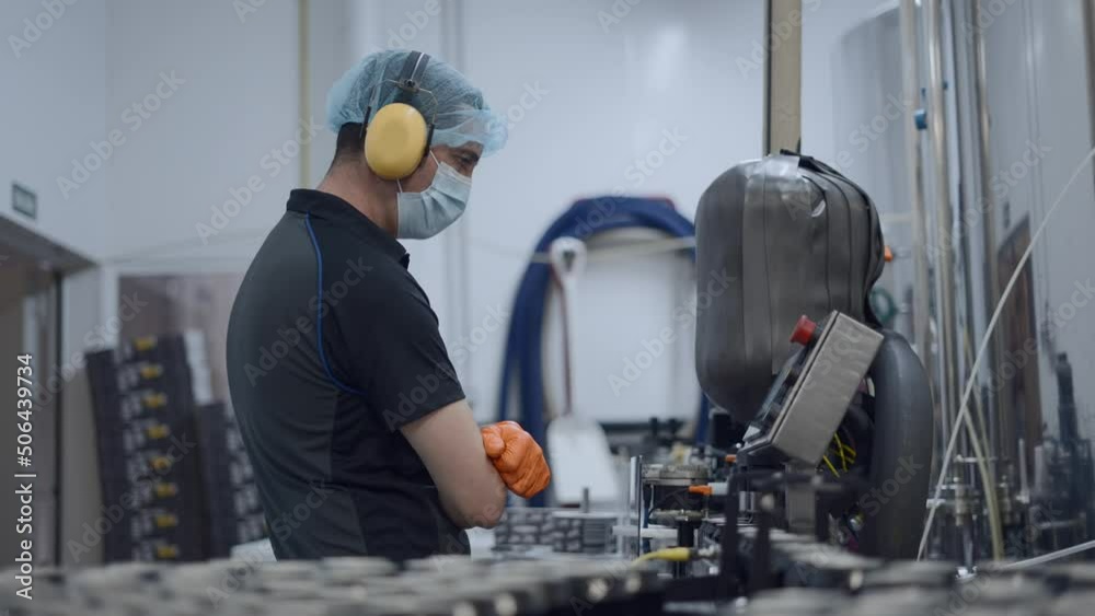 Person Monitoring Production Of Canned Beer In A Factory - close up shot Person Monitoring Production Of Canned Beer In A Factory - close up shot