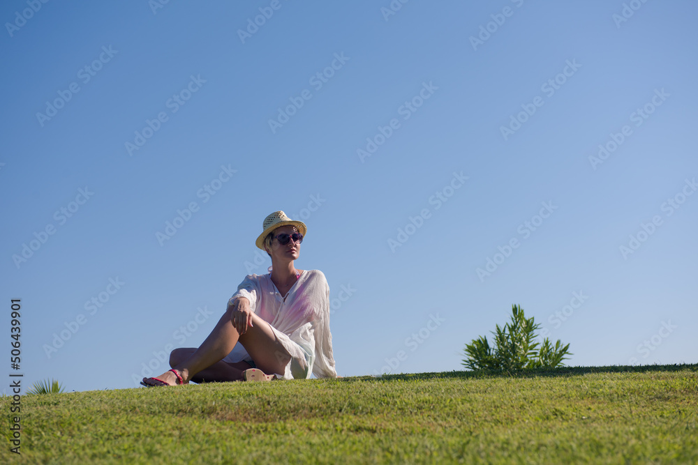 Woman lying and reading her favorite book on a meadow covered with fresh green grass on a sunny summer or spring day. Woman lying and reading her favorite book on a meadow covered with fresh green grass on a sunny summer or spring day.