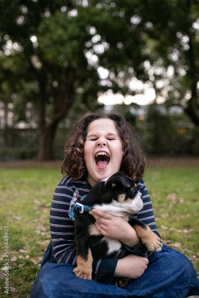 Happy girl outside holding pet bulldog puppy Happy girl outside holding pet bulldog puppy