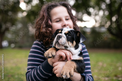 Pet bulldog puppy held by child outside