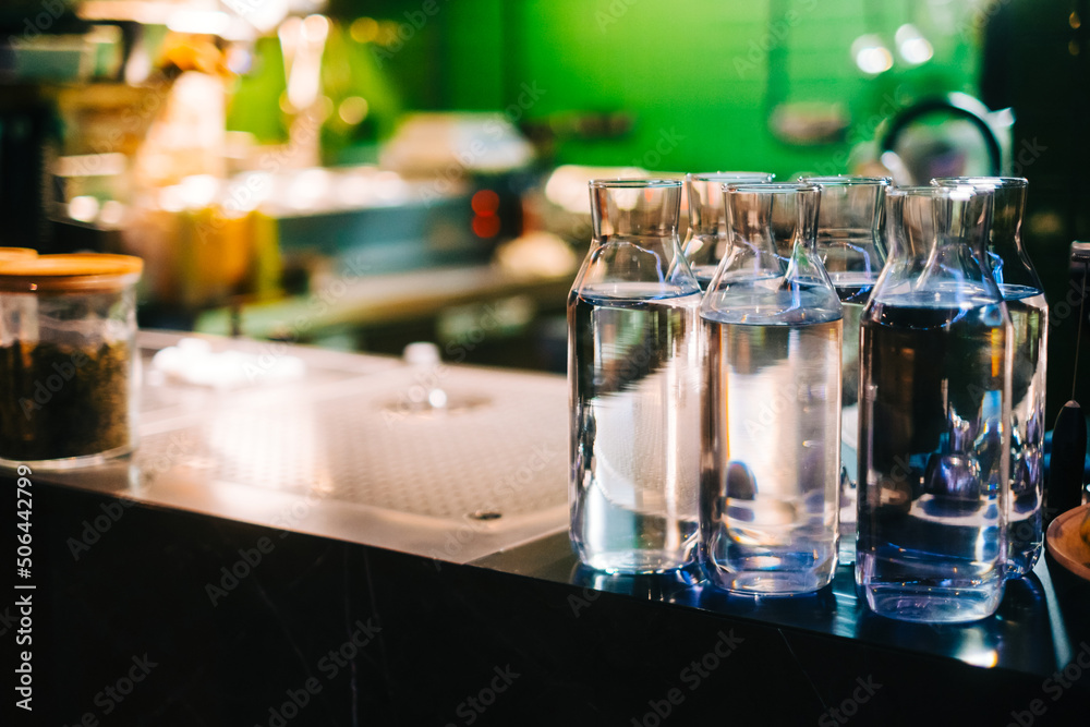 Glass bottles with water on the bar counter in asian restaurant.