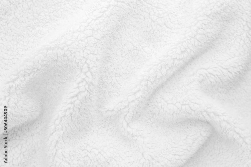 White wavy lambswool texture close up. Warm sheep's wool fabric for blankets. Lining for winter knitted plaid