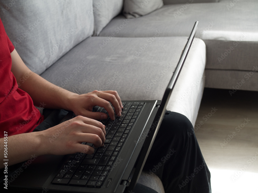 Man working from the sofa at home with the laptop Man working from the sofa at home with the laptop