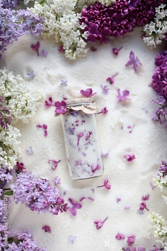 Sugar with lilacs in small glass jars on scattered sugar. Edible flowers in cooking and confectionery. Seasonal spring preparations. Lilacs of different varieties.