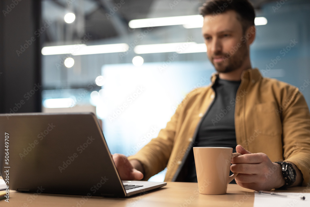 Businessman Using Laptop Drinking Coffee Working Online In Office Businessman Using Laptop Drinking Coffee Working Online In Office