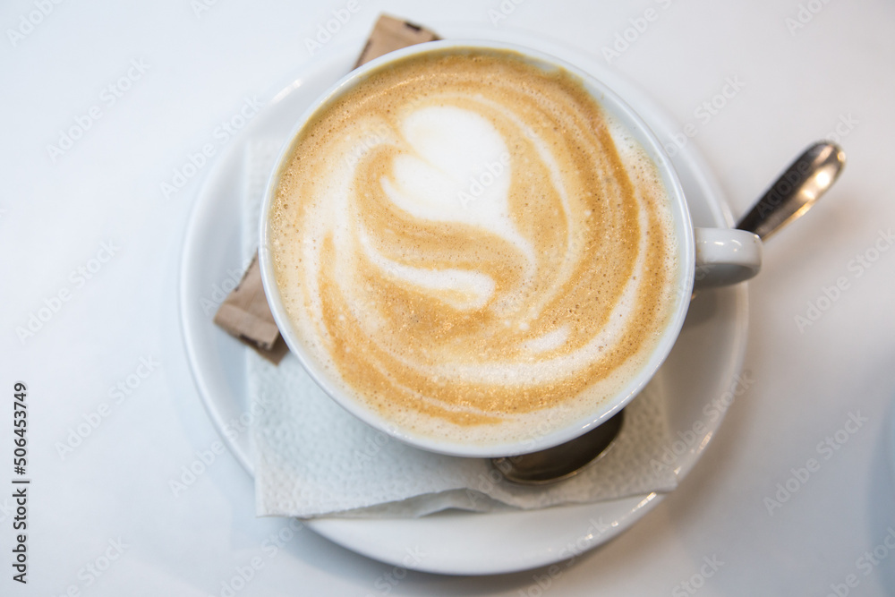 Serving latte in a cafe. Cup napkin spoon and sugar. Serving latte in a cafe. Cup napkin spoon and sugar.