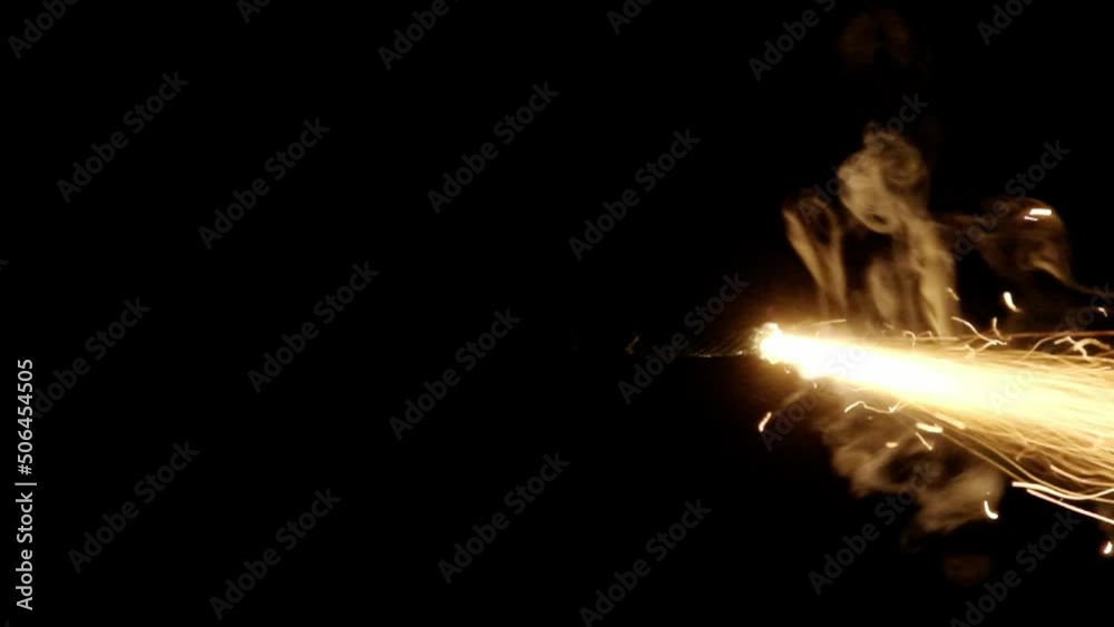 A professional fuse used to ignite bengal fires or bombs, lit with a lighter, burning in slow motion in the darkness. Begin of a long-lasting shot.

