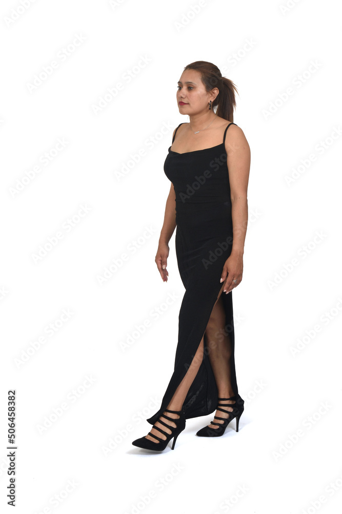 side view of a full portrait of a woman with dress and heeled shoes and ponytail walking on white background side view of a full portrait of a woman with dress and heeled shoes and ponytail walking on white background