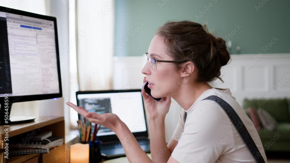 young woman remote work in home office, sitting at table with laptop computer. talks on phone, arguing, blowing up and disputing, . Looks angry and dissatisfied. young woman remote work in home office, sitting at table with laptop computer. talks on phone, arguing, blowing up and disputing, . Looks angry and dissatisfied.