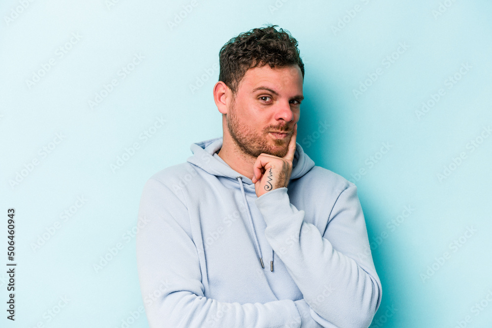 Young caucasian man isolated on blue background contemplating, planning a strategy, thinking about the way of a business. Young caucasian man isolated on blue background contemplating, planning a strategy, thinking about the way of a business.
