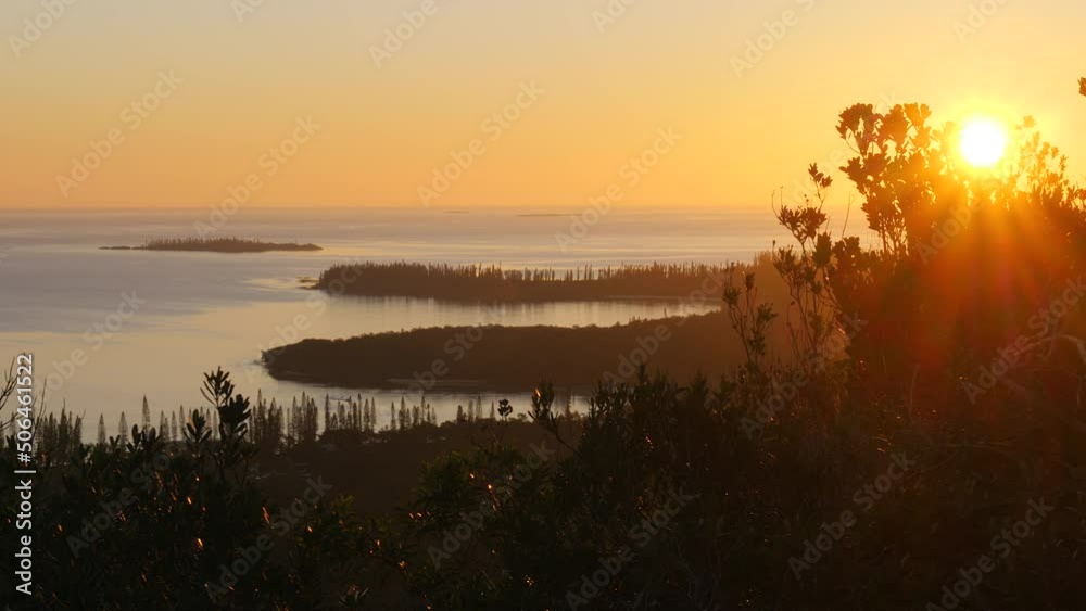 Sun flare through trees at sunset on Isle of Pines, overlooking Pacific Ocean. Tracking shot. Sun flare through trees at sunset on Isle of Pines, overlooking Pacific Ocean. Tracking shot.