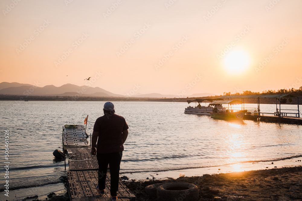 Fototapeta premium Man on dock lakeside sunset in Mexico