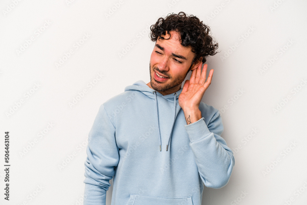 Young caucasian man isolated on white background trying to listening a gossip. Young caucasian man isolated on white background trying to listening a gossip.