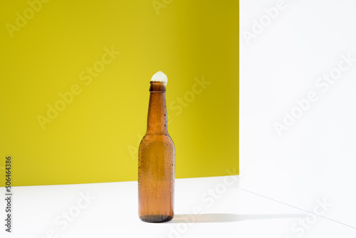 Botella de cerveza fría con espuma que cae. Bebida refrescante  photo
