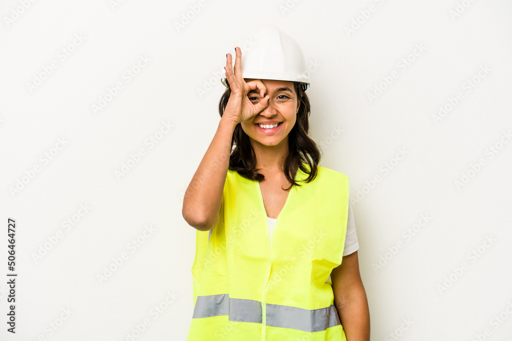 Young laborer hispanic woman isolated on white background excited keeping ok gesture on eye.