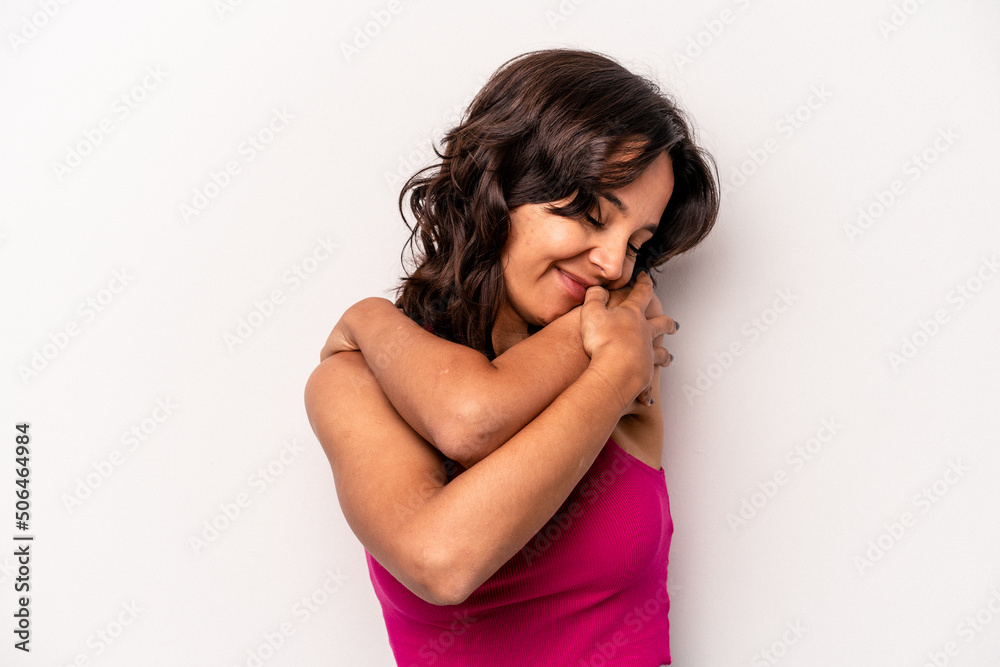 Young hispanic woman isolated on white background hugs, smiling carefree and happy. Young hispanic woman isolated on white background hugs, smiling carefree and happy.
