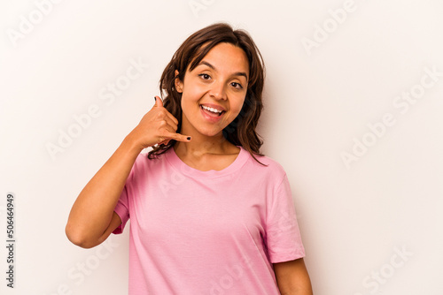 Young hispanic woman isolated on white background showing a mobile phone call gesture with fingers.