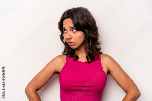 Young hispanic woman isolated on white background confused, feels doubtful and unsure.