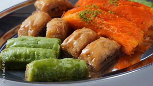 A tray of Turkish pastries including baklava, knafeh -  a Middle Eastern cheese pastry soaked in sweet, sugar-based syrup photo