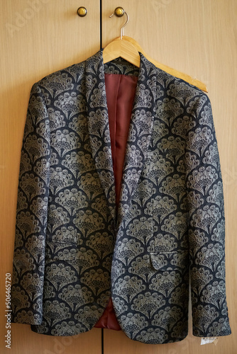 the groom's jacket hangs on the chiffonier door, groom's morning, preparation for the wedding ceremony. groom's jacket close-up, soft focus photo