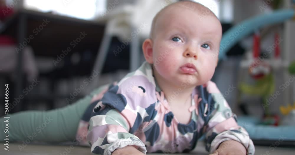 Beautiful blue-eyed baby girl on home floor, close up view Beautiful blue-eyed baby girl on home floor, close up view