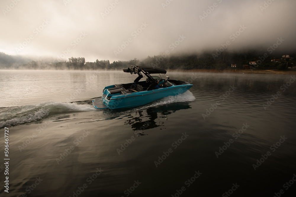 Fototapeta premium bright blue motorboat quickly floating on the water
