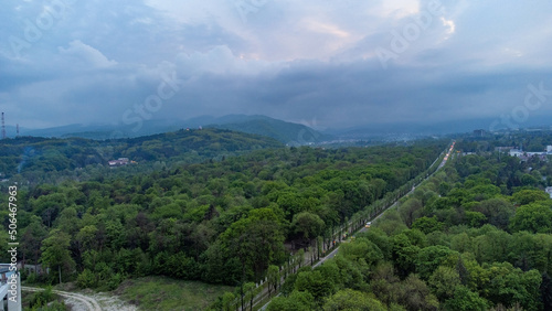 Shooting from a quadcopter. Top view, flat landscape. Forest, park, tree, hills, village, city, road. Bird's-eye.